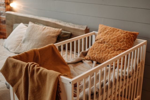 A nursery crib with a firm mattress and a fitted sheet, with no loose bedding or soft toys.