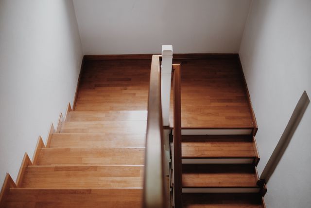 A well-lit staircase with a secure handrail on both sides and a clear, uncluttered path.